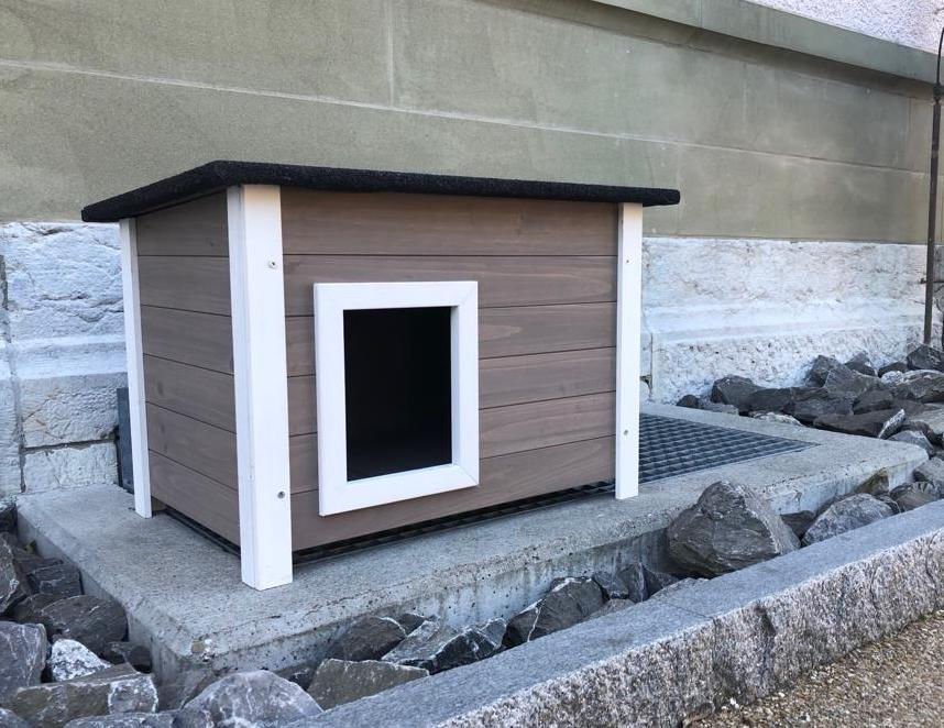 Isoliertes Katzenhaus Oslo mit Bitumendach steht geschützt an einer Hauswand